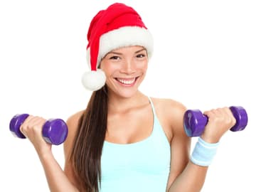Frau mit einer Weihnachtsmütze und Hanteln Frau mit Hanteln