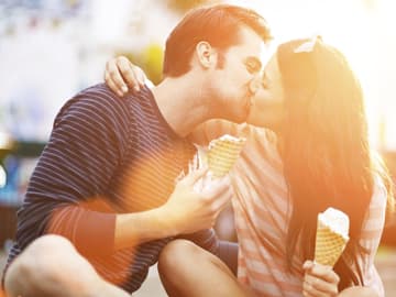 Ein Liebespaar küsst sich und hat ein Eis in der Hand Paar küsst sich