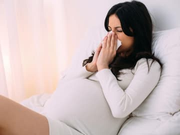 schwangere Frau niest Erkältung in der Schwangerschaft