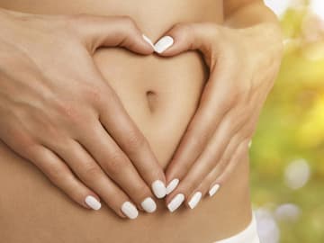 Frau formt Herz auf dem Bauch darmsanierung