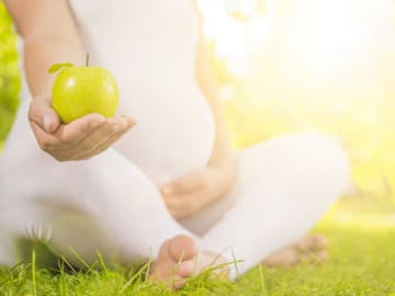 schwangere Frau mit Apfel Vitamine in der Schwangerschaft