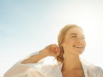 Strahlende-Frau-und-Sonnenschein Sonne macht den Menschen munter.