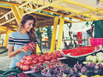 Frau an einem Obststand Frau an einem Obststand sucht Früchte aus