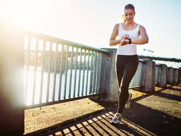 Frau_Sport_Uhrzeit Frau schaut auf Uhr, draußen, Sport machen