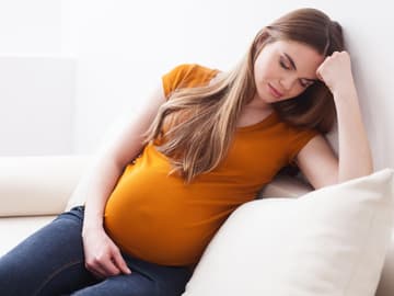 Schwangere_Frau Schwangere Frau sitzt auf dem Sofa