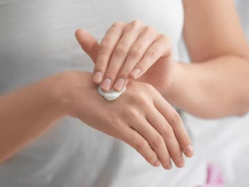tipps-gegen-trockene-haende Frau cremt sich die Hände ein