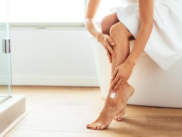tipps-wellness-zuhause Frau cremt sich Beine ein