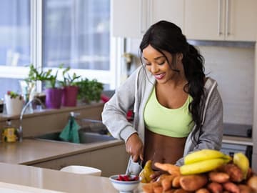 Sportliche Frau schneidet Obst Sportliche Frau schneidet Obst