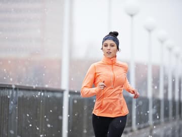 Frau_Winter_joggen Frau joggt im Winter draußen