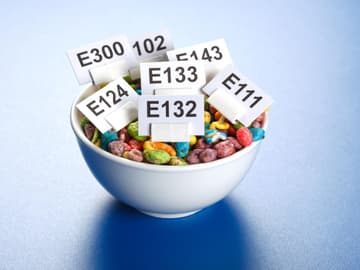 Lebensmittelfarbe E-Nummern und bunte Cornflakes in einer Schüssel
