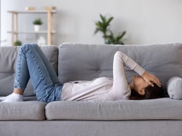 Frau_liegt_auf_Couch Frau liegt auf Couch
