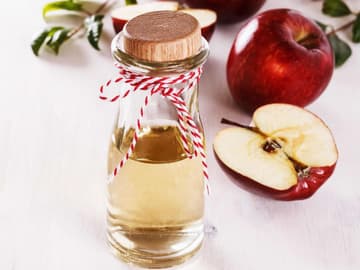Flasche mit Apfelessig und Äpfel Flasche mit Apfelessig und Äpfel