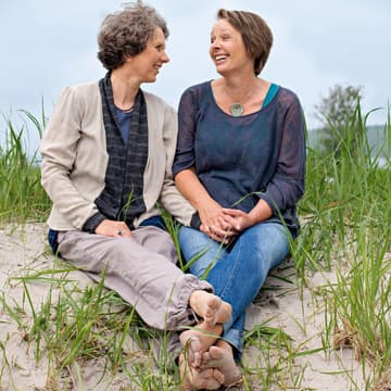 Zwei Freundinnen lachen am Strand Zwei Frauen am Strand