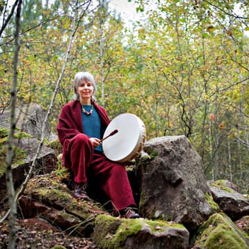 Die Schamanen Barbara sitzt im Wald mit einer Trommel in der Hand Barbara ist Schamanin