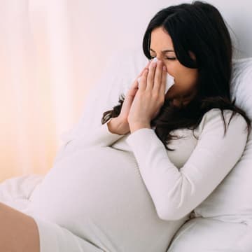schwangere Frau niest Erkältung in der Schwangerschaft
